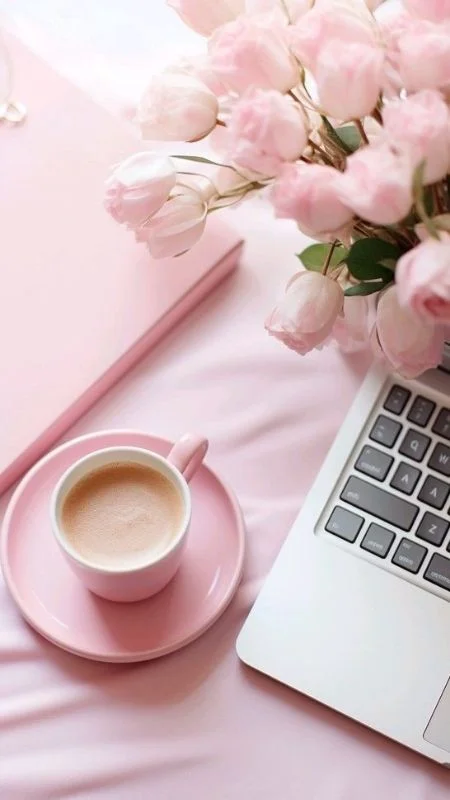 Bó tulip hồng bên tách cà phê và máy tính xách tay