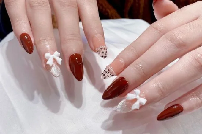 Móng tay màu đỏ đậm trang trí bow trắng