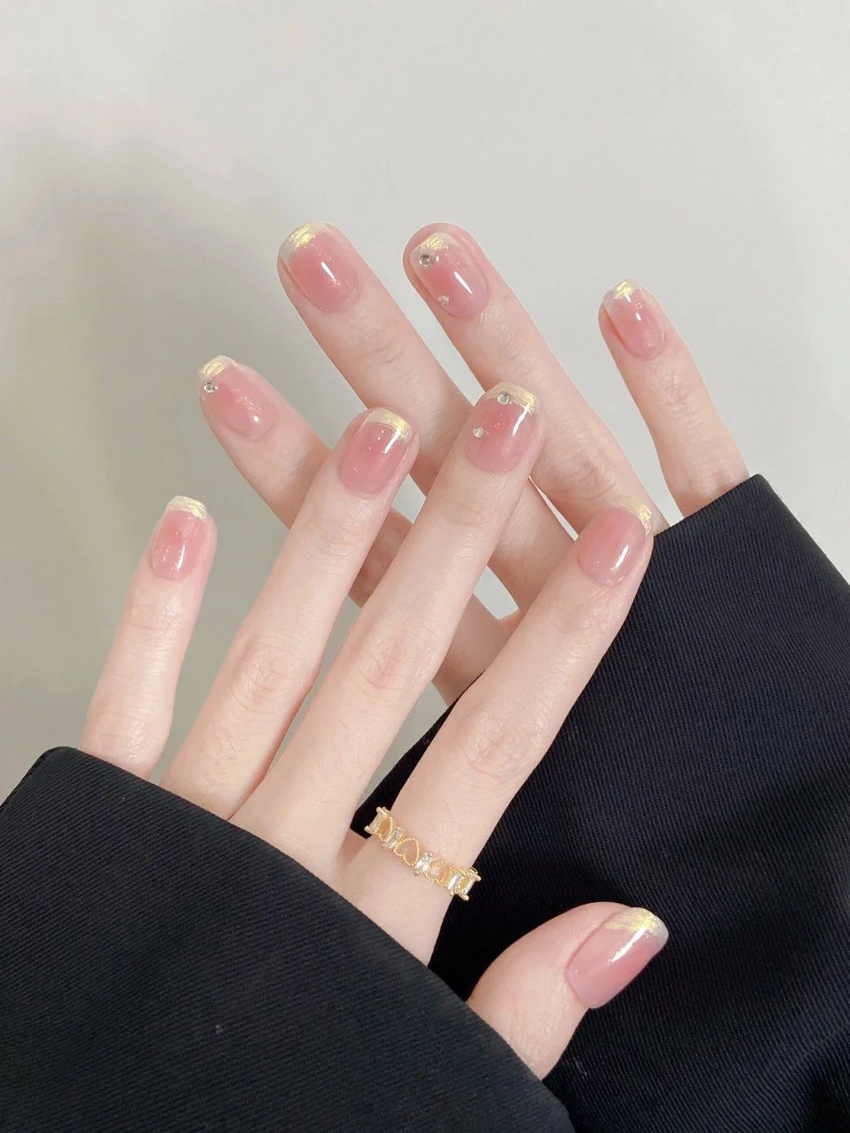 Mẫu móng tay hồng nhạt dáng dài thanh lịch trên bàn tay đeo nhẫn