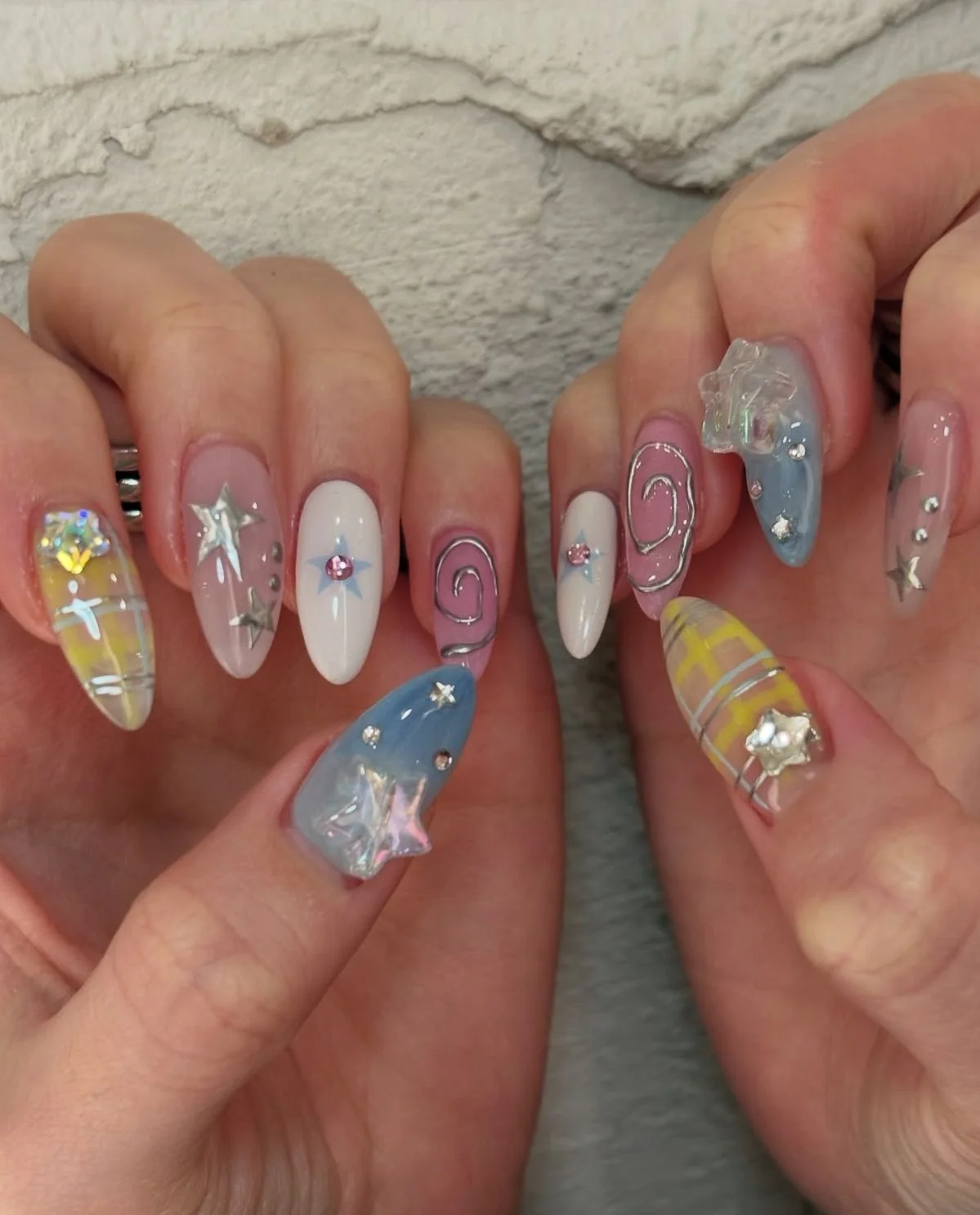 Bộ móng tay nhiều màu xanh, hồng và vàng với họa tiết hoa cùng charm trang trí