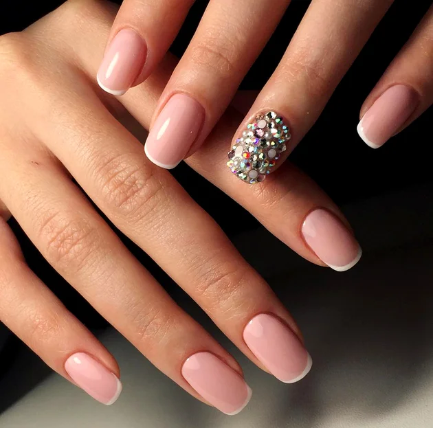 Mẫu móng tay hồng sữa dáng oval với một ngón đính đá lấp lánh