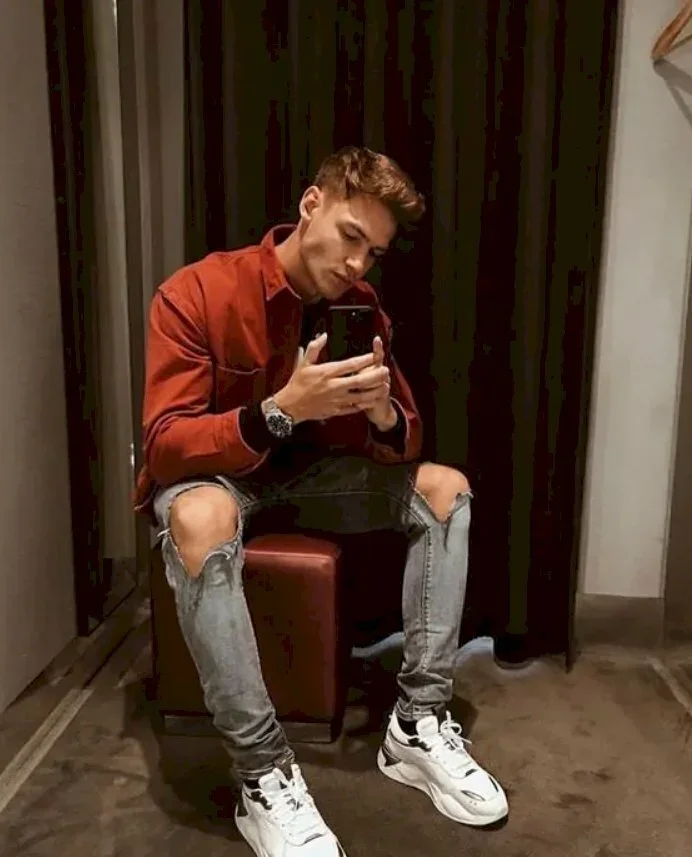 Kiểu tạo dáng đàn ông, kiểu ngồi đầy nam tính với chiếc quần phong cách street style và áo phông đỏ, đầu hơi nghiêng cùng 2 tay cầm điện thoại tự sướng vào