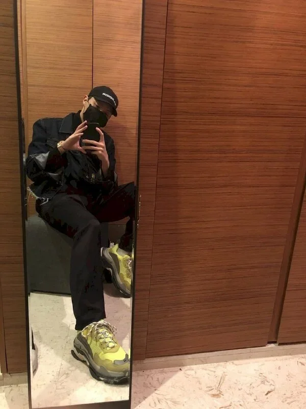 Kiểu tự sướng nam cùng chiếc gương với thời trang màu đen và giày sneaker màu xanh nổi bật phong cách năng động, nam tính cùng dáng ngồi dựa tường thoải mái, 1