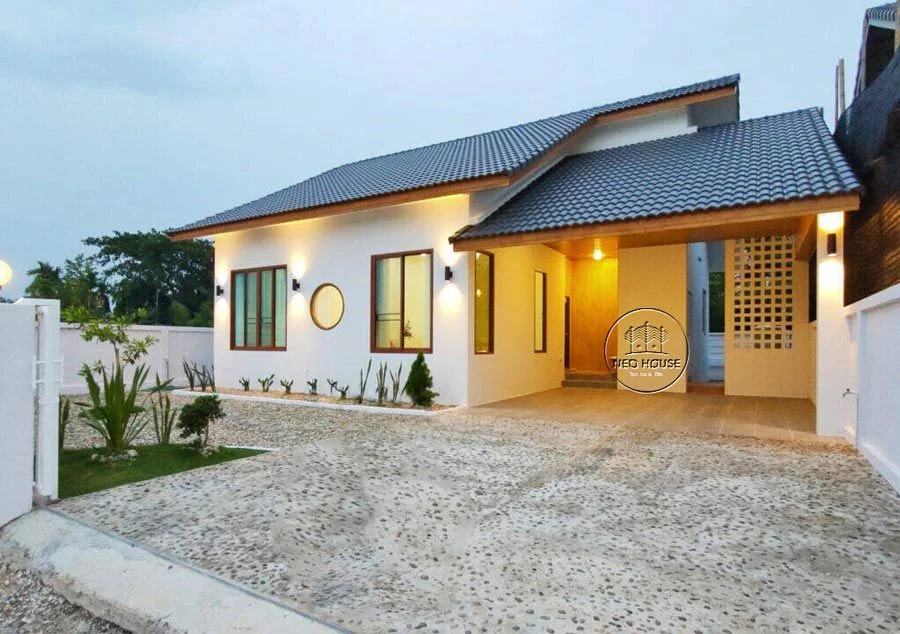 Mẫu nhà cấp 4 hiện đại mái dốc, mặt tiền trắng và sân lát sỏi