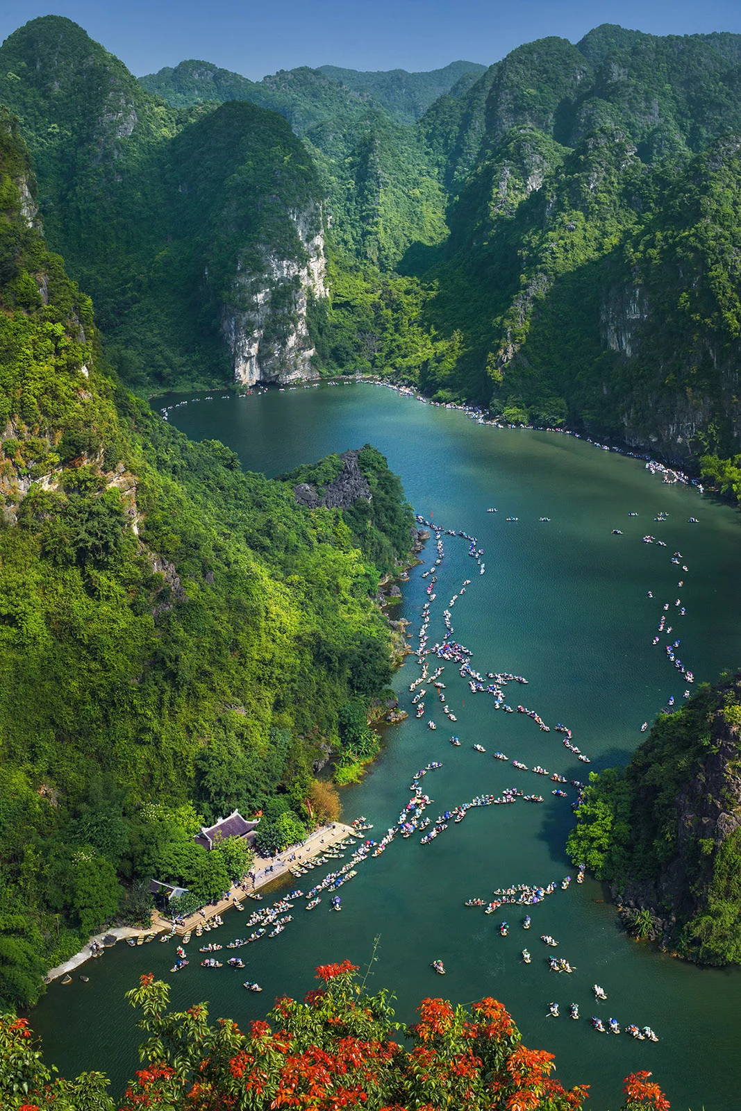 Phong cảnh đẹp tại Tràng An với những chiếc thuyền nhỏ trên sông giữa núi đá vôi hùng vĩ.